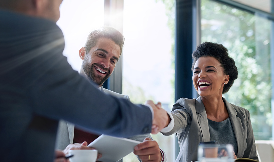 business partners shaking hands across a table